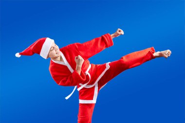 Tekme bacak Noel Baba gibi giyinmiş atlet atıyor