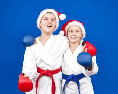 Çocuklar Noel Baba kapaklar ve ellerinde kırmızı ve mavi bindirmeleri