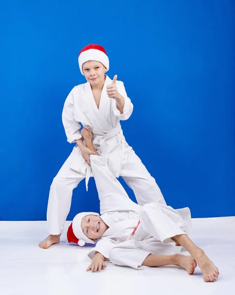 Two boys are trained judo throws in Santa Claus caps — Stock Photo, Image