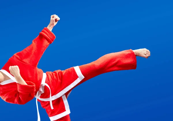 With white belt and in a suit of Santa Claus the sportswoman is beating kicking — Stock Photo, Image