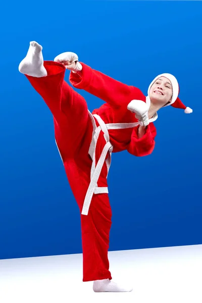 Med vitt överlägg på händerna och i kostym slår jultomten flicka ett kick ben — Stockfoto