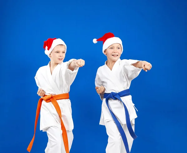 Blow hand the boys are beating in caps of Santa Claus — Stock Photo, Image