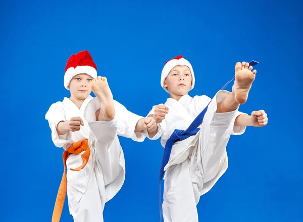 Los niños con gorras Santa Claus están entrenando pata de patada — Foto de Stock