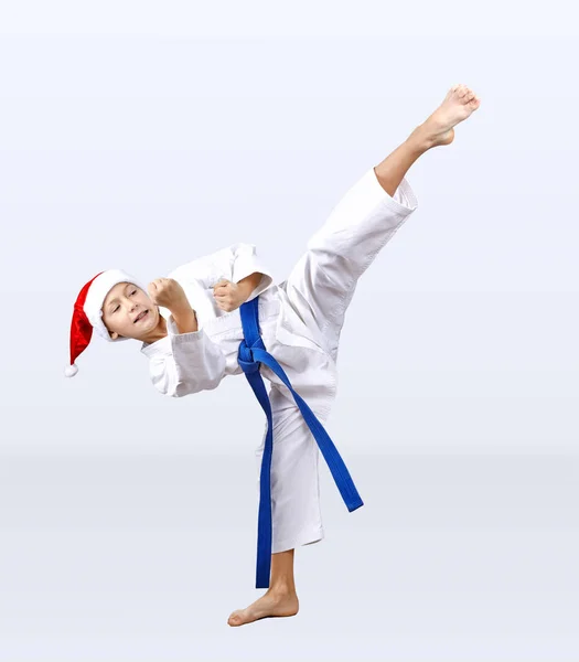Niño en karategi y sombrero de Santa Claus golpea una patada — Foto de Stock