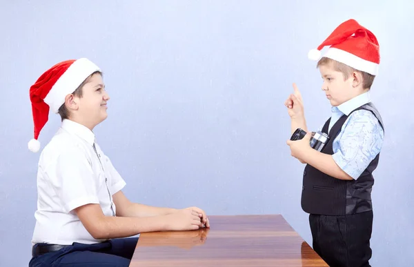 In Weihnachtsmannmützen verbringen zwei Brüder einen Fototermin — Stockfoto