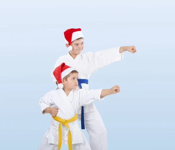 Brothers in caps of Santa Claus are beating punch arm — Stock Photo, Image