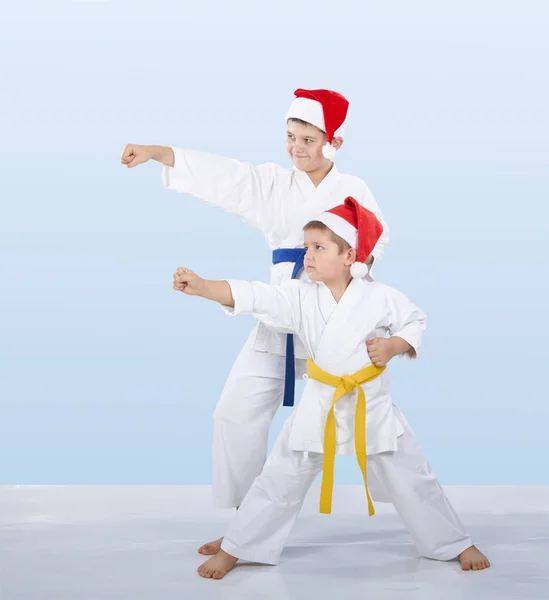 Dos karateka en gorras de Santa Claus golpearon el brazo del golpe — Foto de Stock