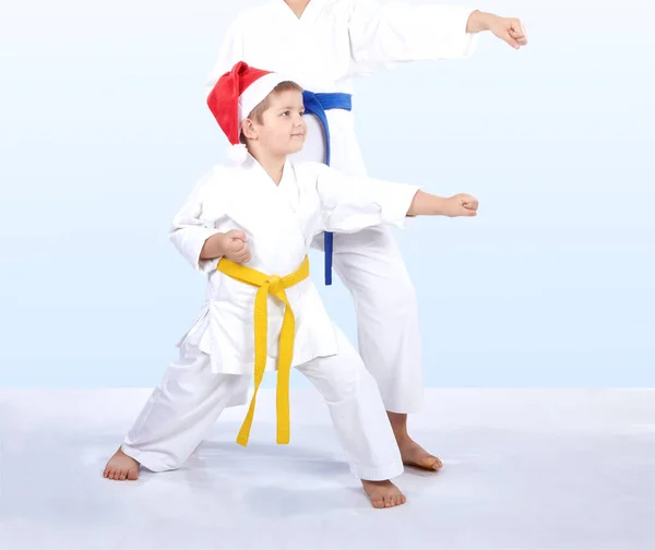 Children in cap Santa Claus are beating punch arm — Stock Photo, Image
