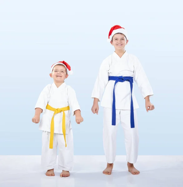 Dois irmãos atleta em bonés de Papai Noel no karatê rack — Fotografia de Stock