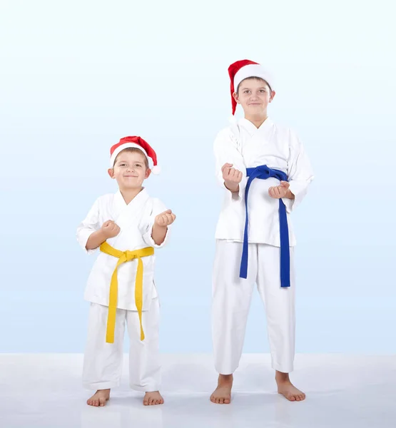 En estante de karate están de pie los atletas en gorras de Santa Claus —  Fotos de Stock