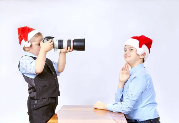 El hermano menor está fotografiando al mayor con una gorra de Santa Claus — Foto de Stock