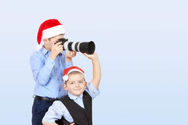 Irmão ajuda irmão a fotografar em um boné de Papai Noel — Fotografia de Stock