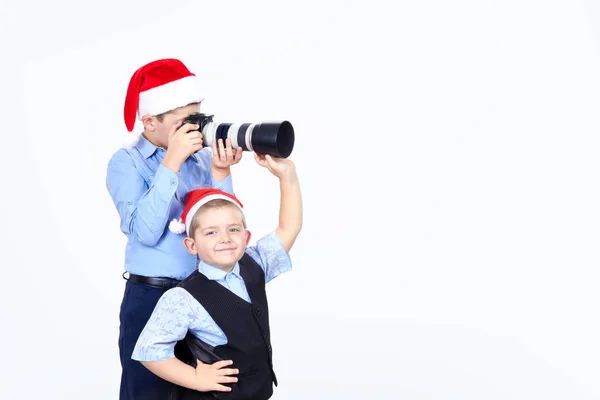 No fundo branco isolado meninos estão fotografando em bonés de Papai Noel — Fotografia de Stock
