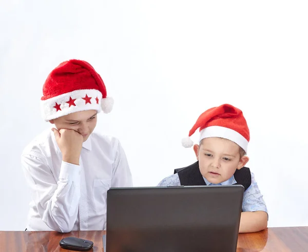 Les garçons en casquettes du Père Noël regardant un ordinateur portable — Photo