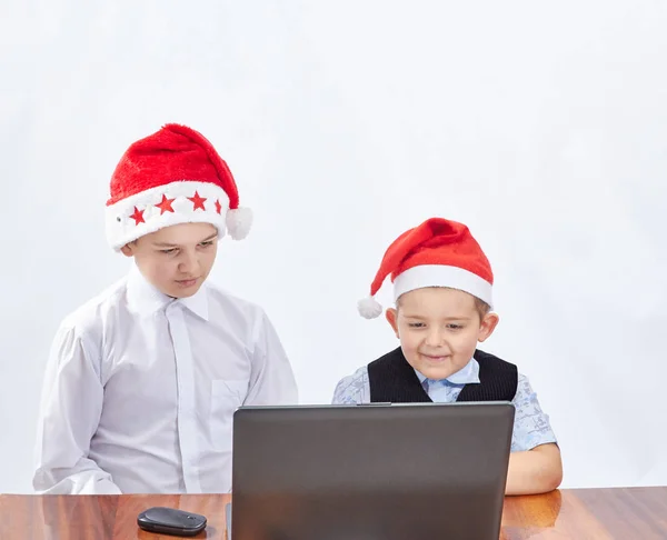 Dans les casquettes du Père Noël enfants regarder un ordinateur portable — Photo