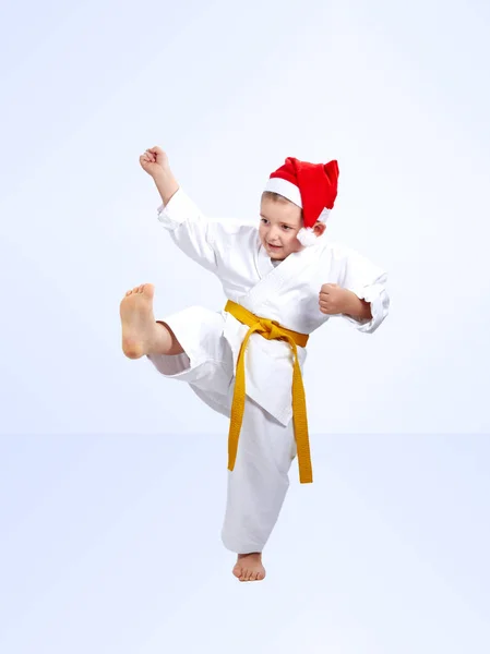 Boy athlete beats a kick in the cap of Santa Claus — Stock Photo, Image