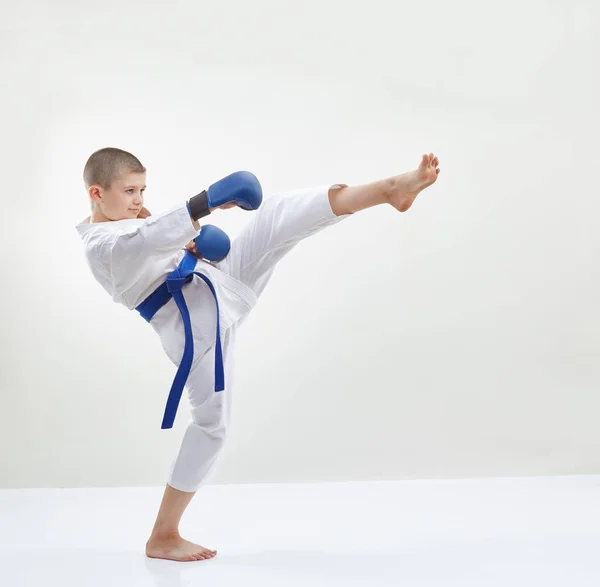 High kick leg the athlete is beating with blue overlays on hands — Stock Photo, Image