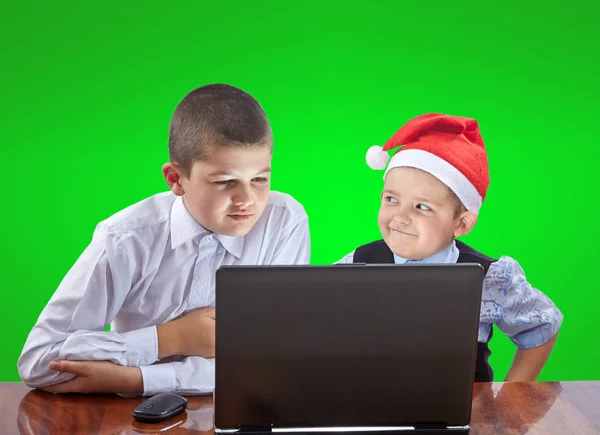 Les garçons regardent un ordinateur portable assis à la table — Photo