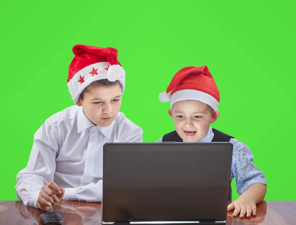 Zwei Brüder schauen auf einen Laptop, der an einem Tisch sitzt — Stockfoto
