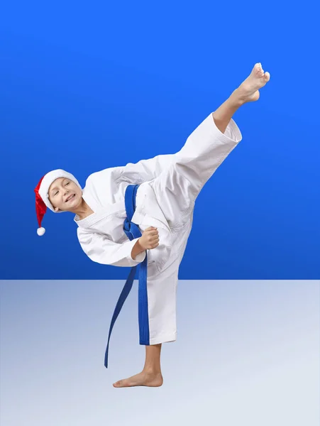 In cap of Santa Claus sportsman beats roundhouse kick — Stock Photo, Image