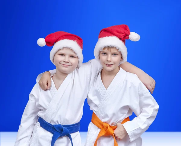 På en blå bakgrund pojkar i kepsar av Santa Claus — Stockfoto
