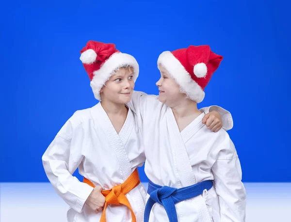 Deux amis en casquettes du Père Noël sur un fond bleu — Photo