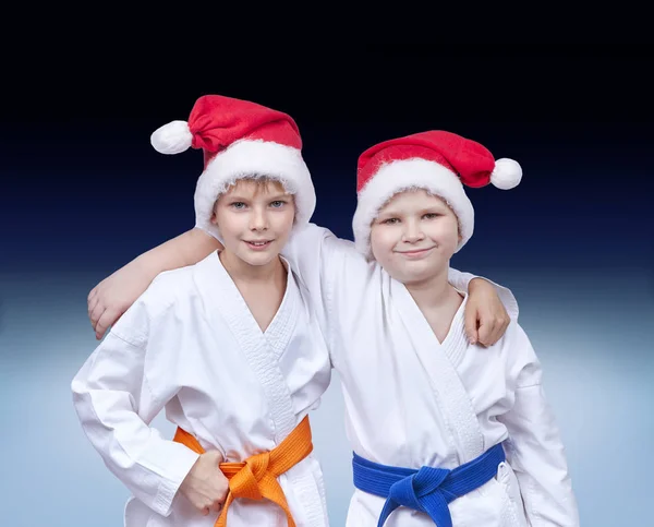 Barn idrottare i caps jultomten på en tonad bakgrund — Stockfoto