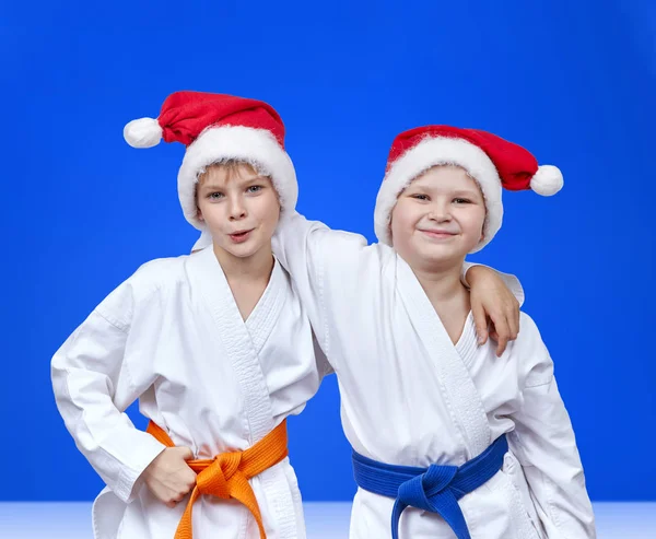 Freunde in Mützen des Weihnachtsmannes auf blauem Hintergrund — Stockfoto