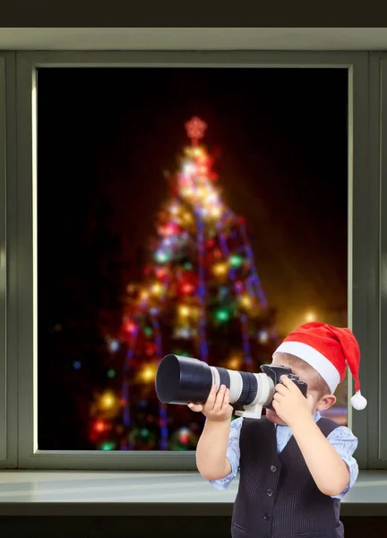 Το αγόρι φωτογράφηση στο φόντο του το χριστουγεννιάτικο δέντρο έξω από το παράθυρο — Φωτογραφία Αρχείου