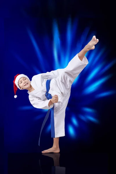 En karategi atleta golpea patadas contra el brillo azul — Foto de Stock