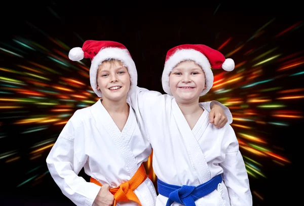 In Mützen von Weihnachtsmannfreunden auf dem Hintergrund heller Strahlen — Stockfoto