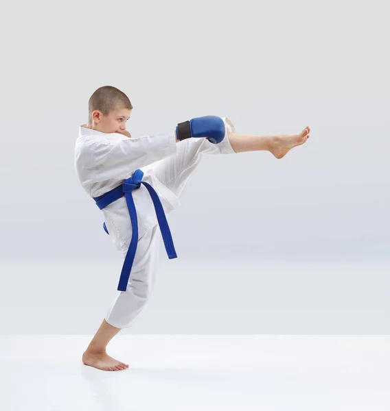 Sporcu eğitim ellerinde mavi bindirmeleri ile bacak tekme — Stok fotoğraf