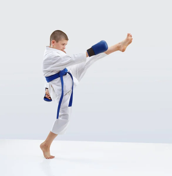 High kick forward karateka is beating in karategi — Stock Photo, Image