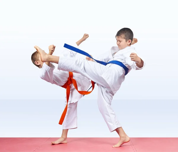 On a red mat two athletes are beating kicks — Stock Photo, Image