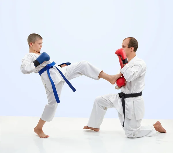 With black belt trainer teaches the athlete to beat kick leg on the simulator — Stock Photo, Image