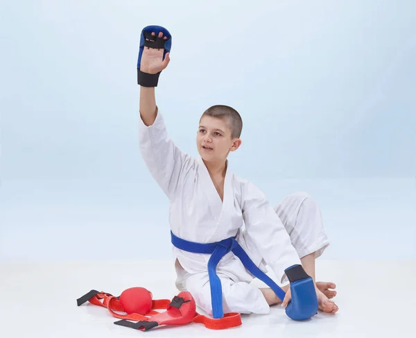 Sobre un fondo ligero atleta de karate levantó la mano en saludo —  Fotos de Stock