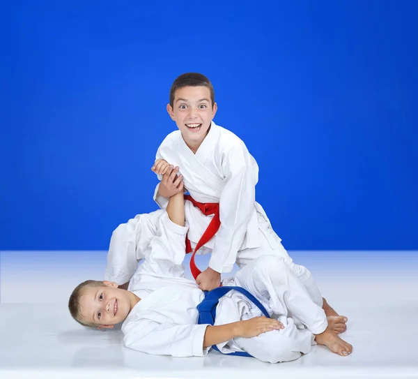På en blå bakgrund tränar pojkarna kasta och avslutningsrörelser — Stockfoto
