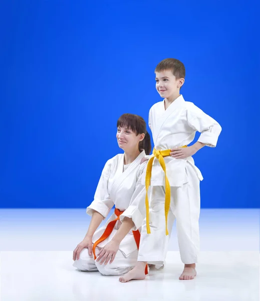 On light blue background mother and son the athletes — Stock Photo, Image