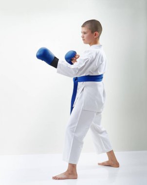 Karateka çocuktur elinde mavi bindirmeleri ile raf karate