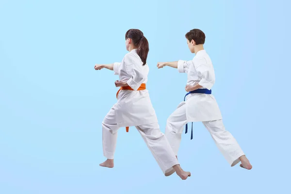 På en ljusblå bakgrund tränar flickorna punch hand — Stockfoto