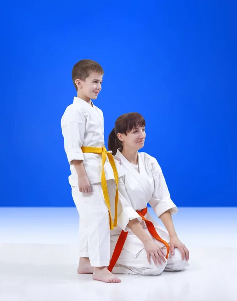 Sobre un fondo azul madre e hijo los atletas con una sonrisa en la cara — Foto de Stock