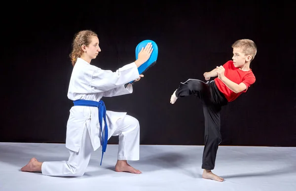 The boy beats a kick on the simulator in the hands of an athlete — Stock Photo, Image