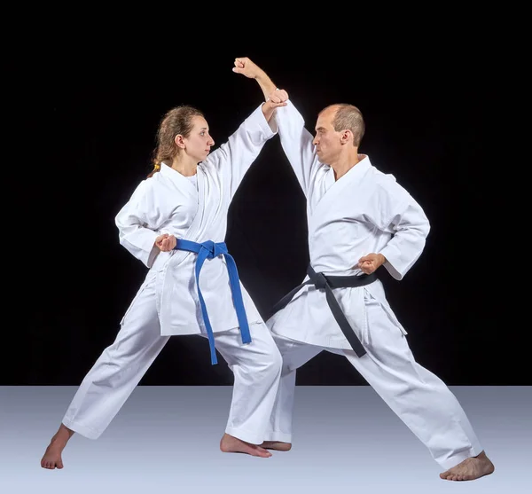 Twee volwassen atleten trainen een kick en een blok van de hand — Stockfoto