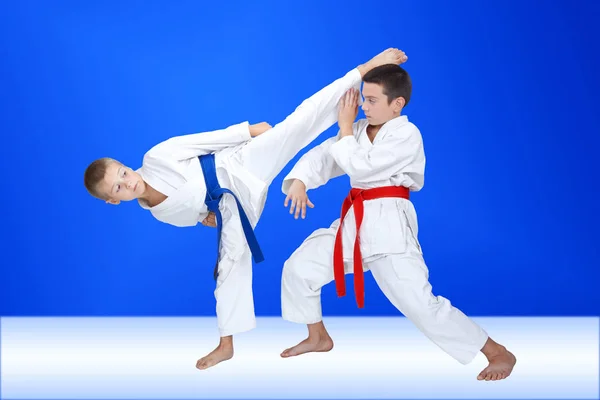 Boys in karategi are training a circular kick and block — Stock Photo, Image