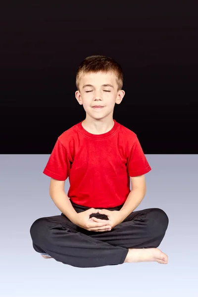 Niño sentado en pose de meditación Imagen De Stock