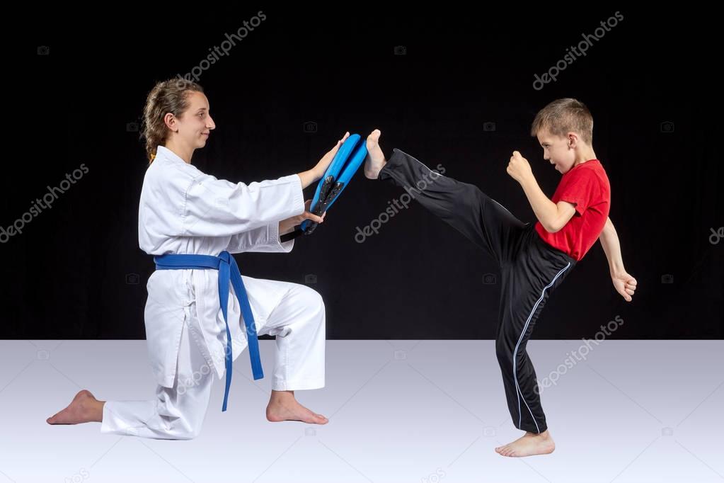 Small athlete trains a kick on the simulator