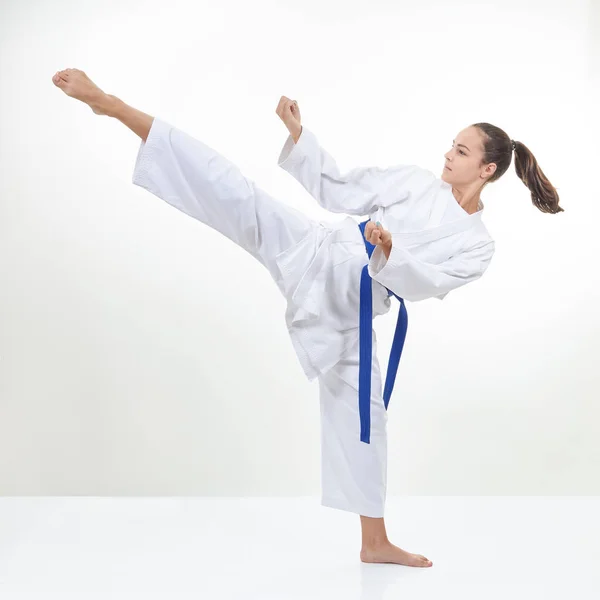 In Karategi schlägt die Sportlerin ein hohes Kick-Bein — Stockfoto