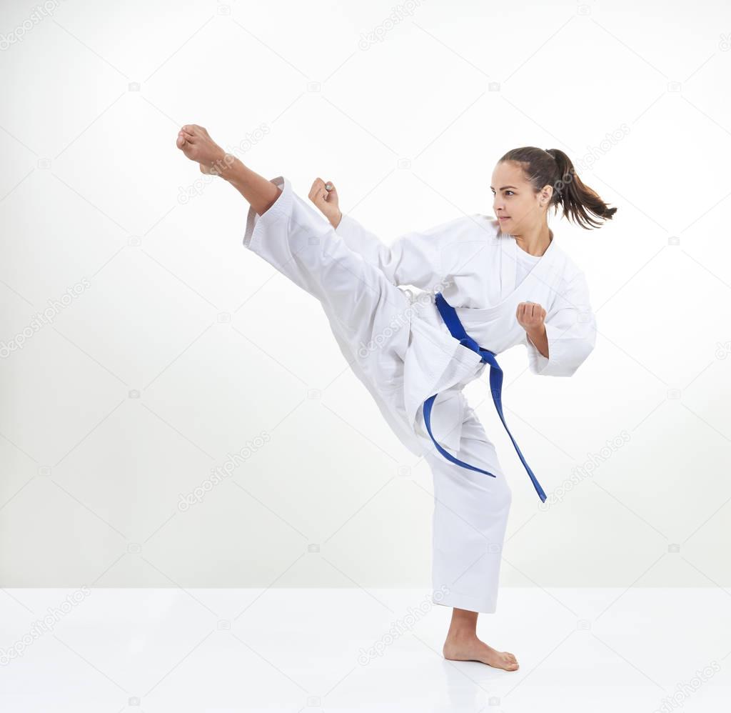 An adult sportswoman in karategi beats kick