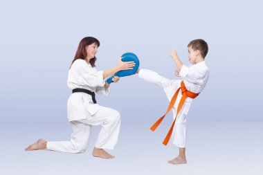 Son and mother are training kick in karategi clipart