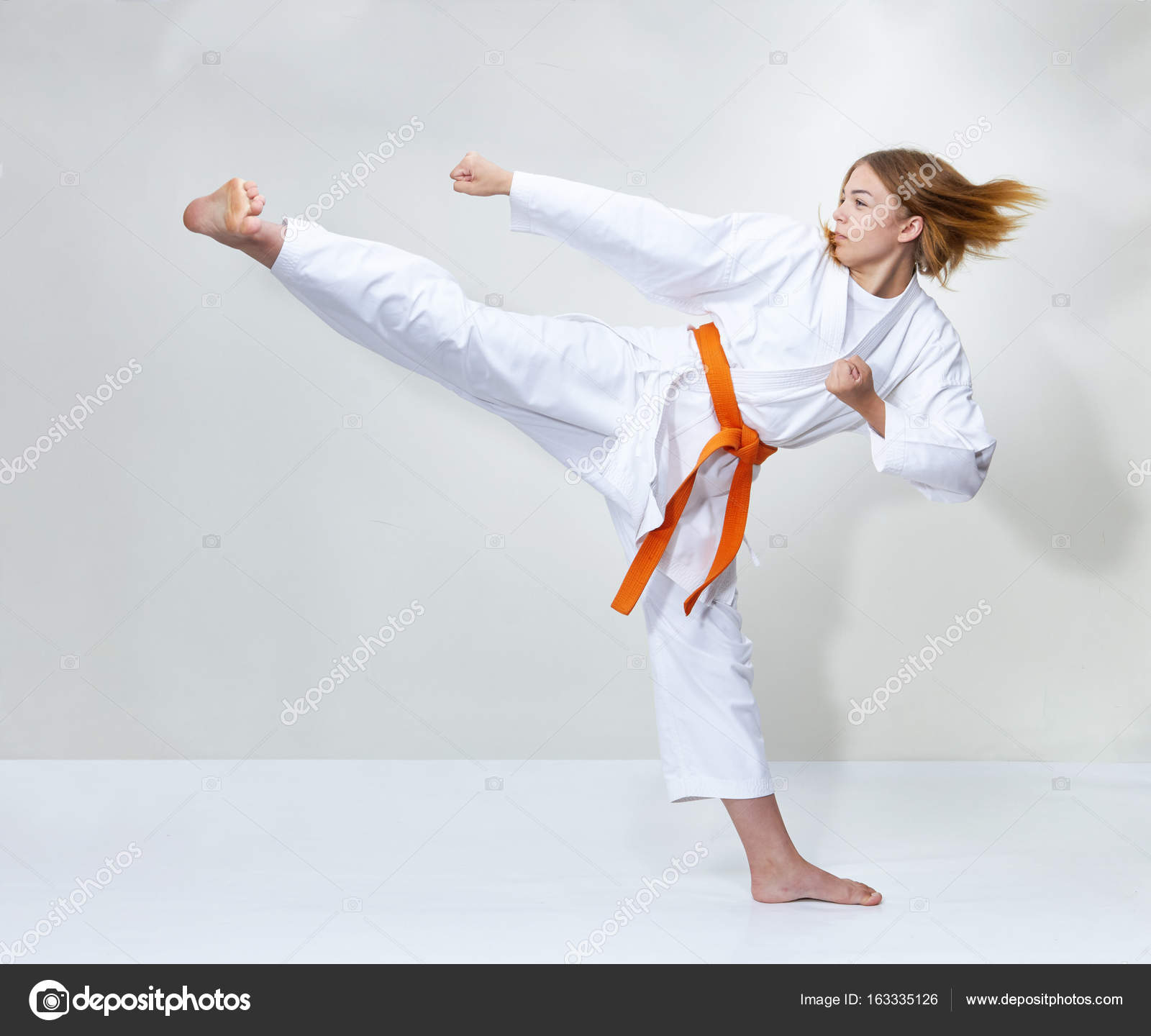 With an orange belt, athlete trains a Stock Photo by 163335126